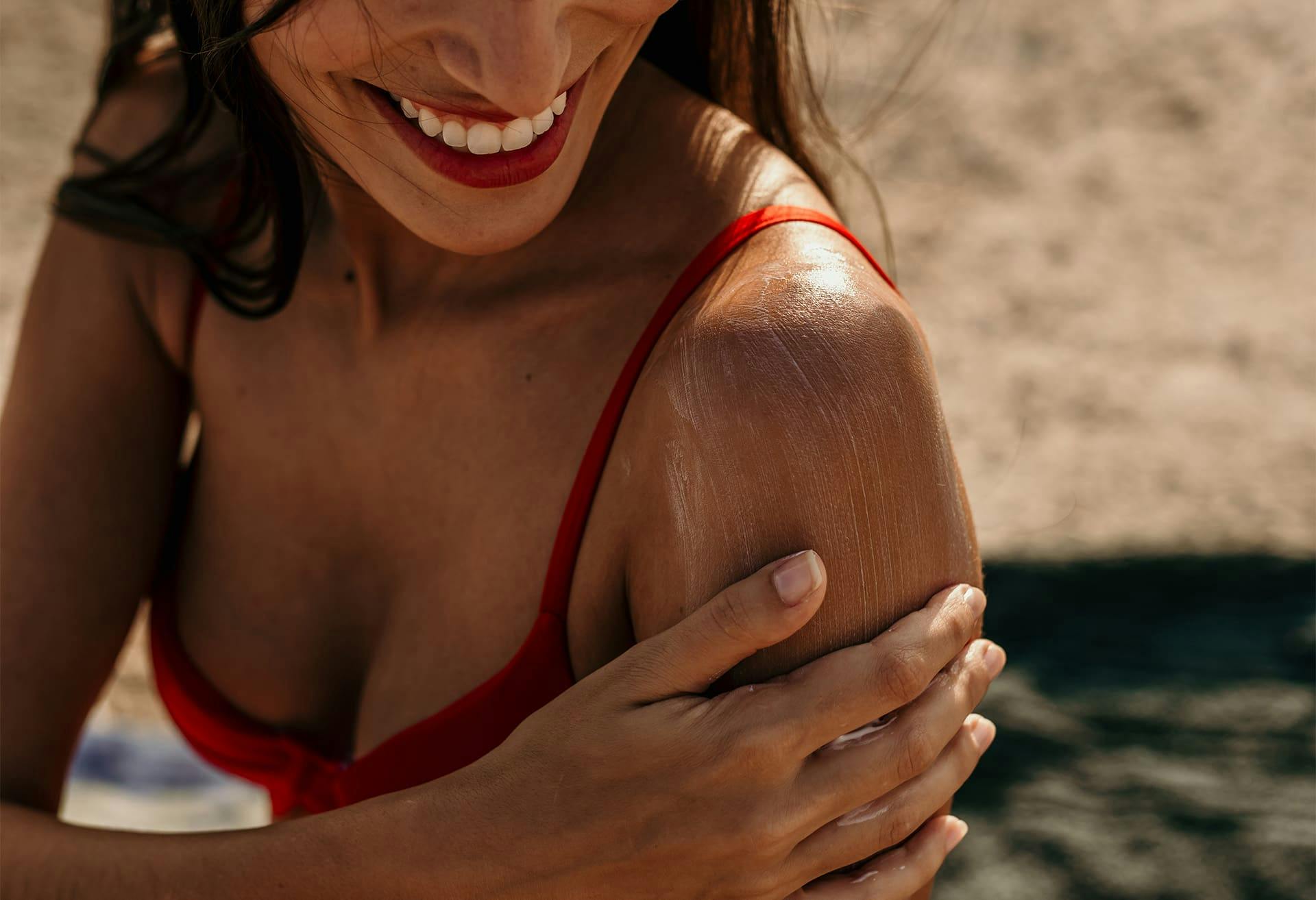 Woman smiling and touching her shoulder