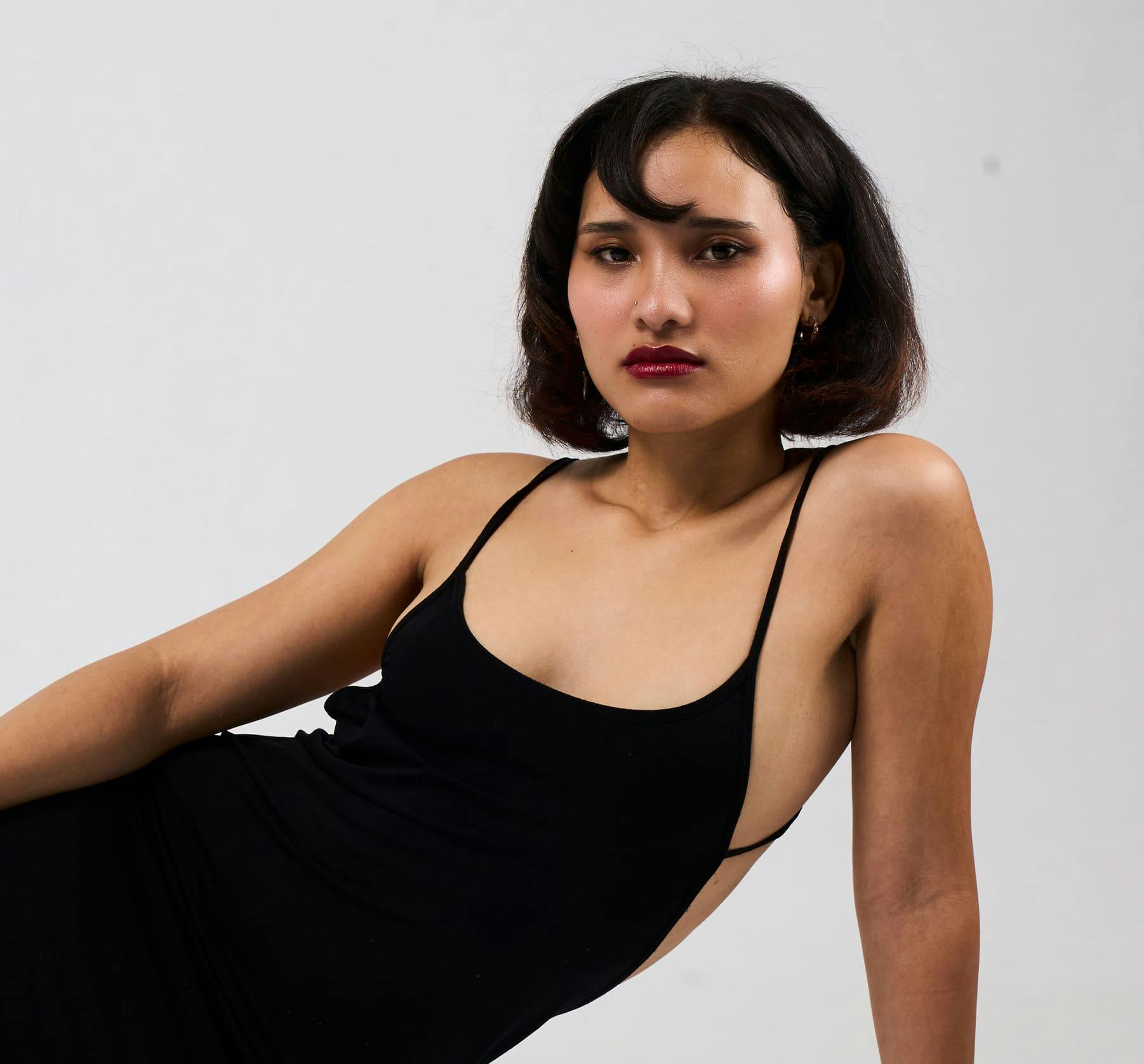 Woman sitting on the floor in a black dress