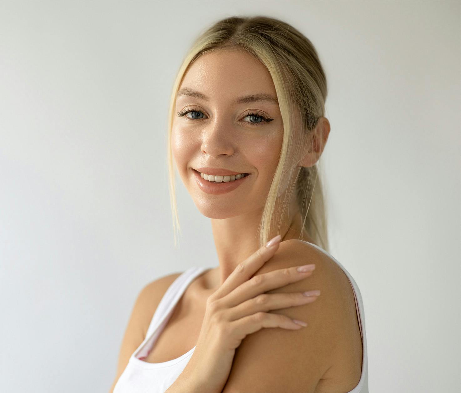 woman smiling with hand on shoulder