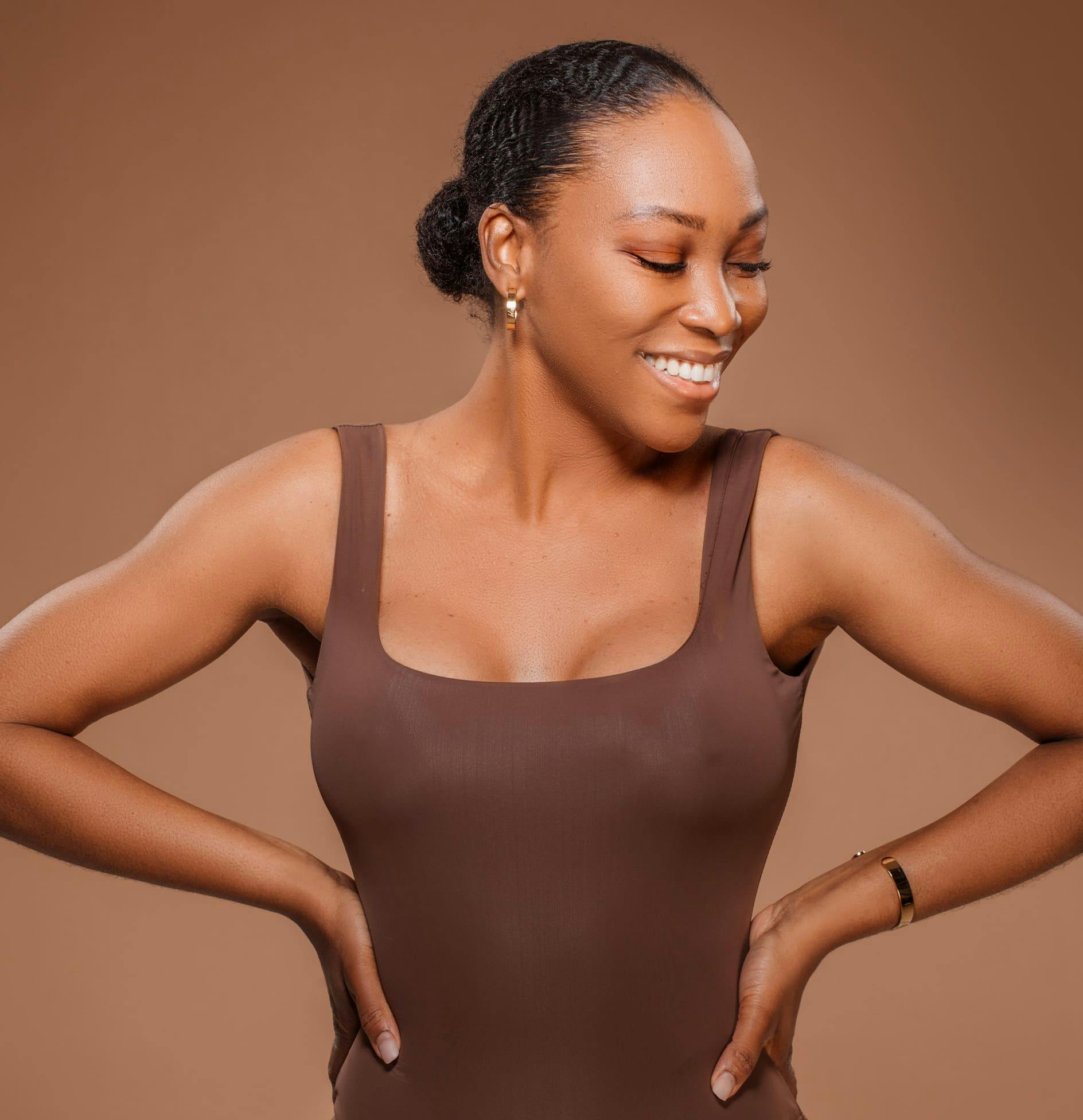 A woman smiling with her hands on her hips