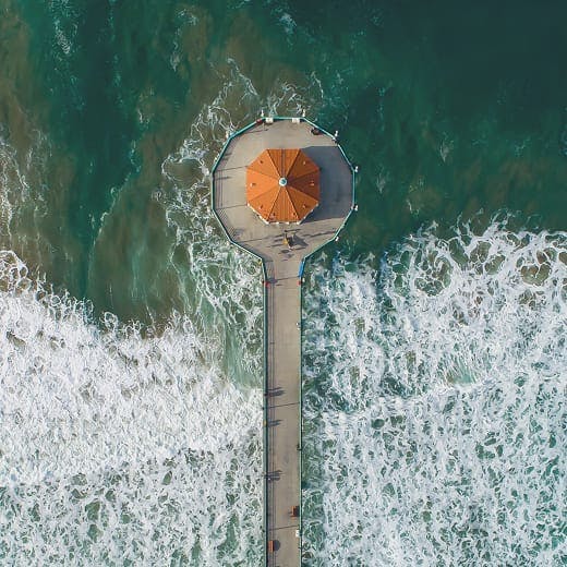 Dock out from shore with waves crashing around it