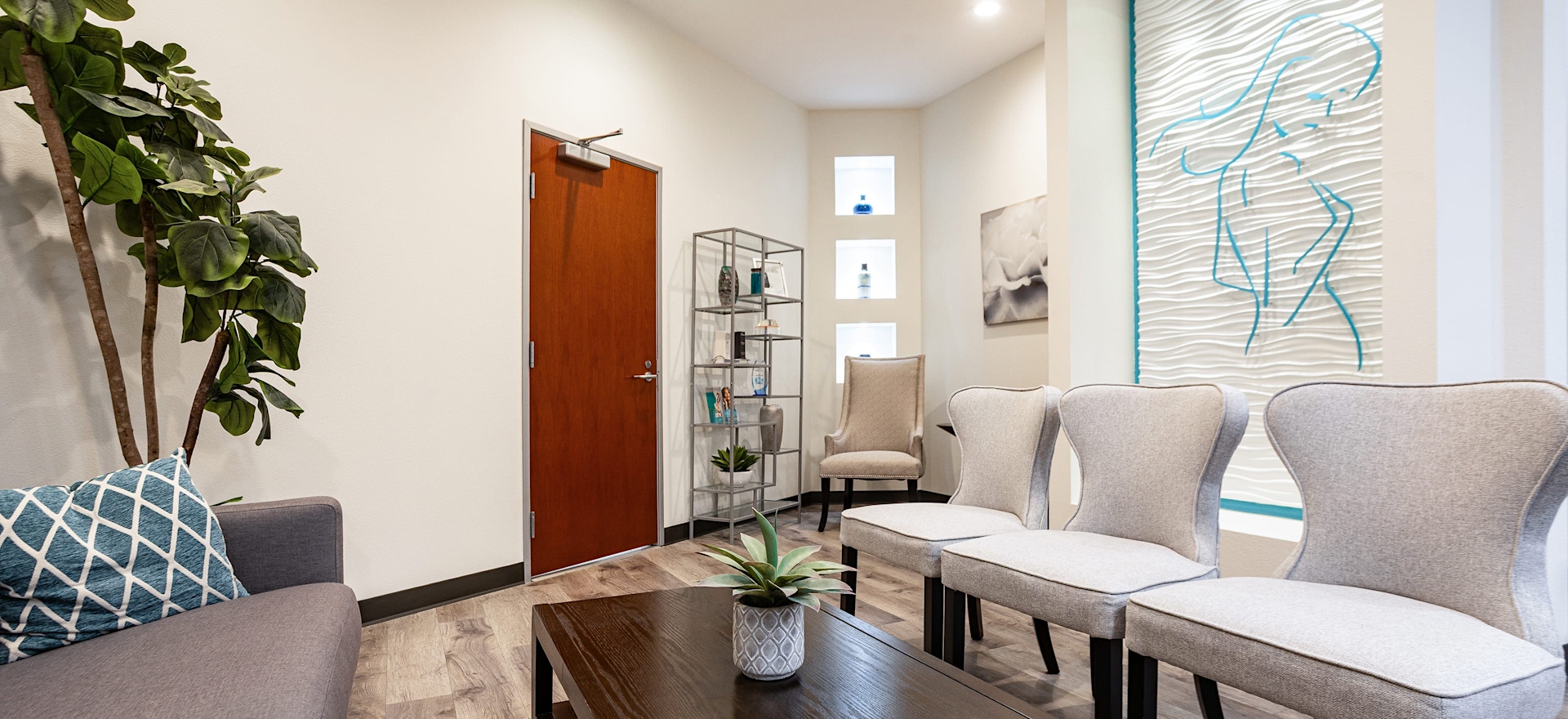 Waiting room of Gupta Plastic Surgery office featuring grey chair and couch