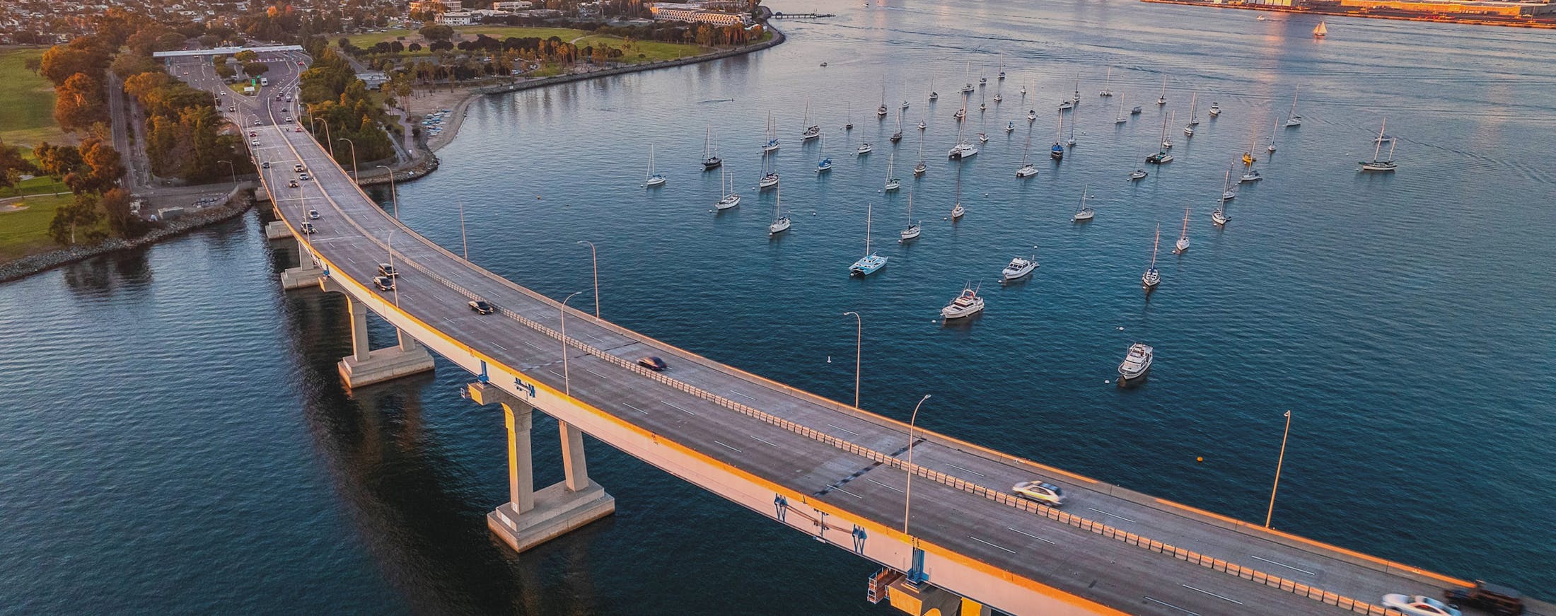 Bridge overpassing a river with dozens of boats