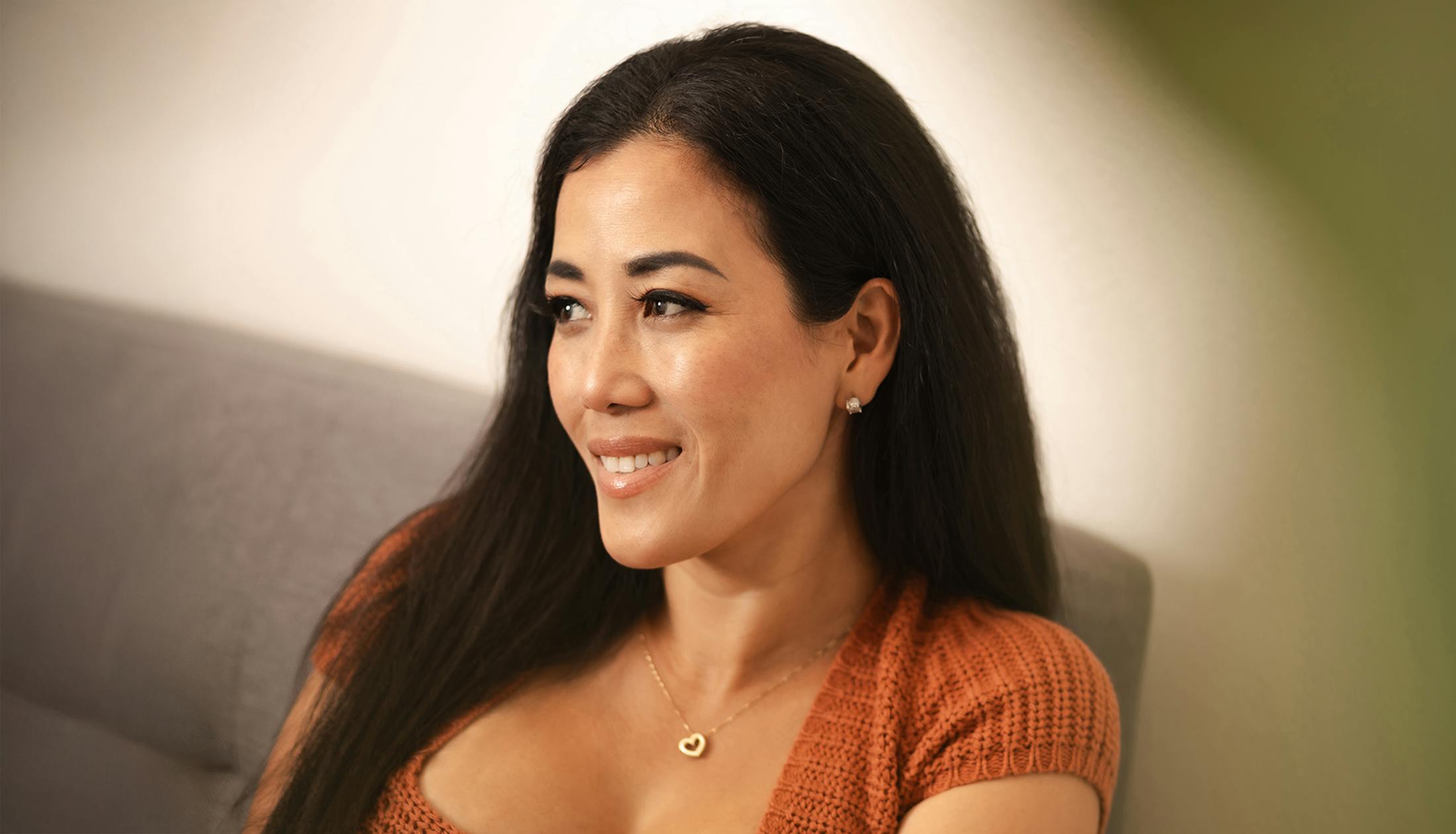 woman sitting on couch smiling