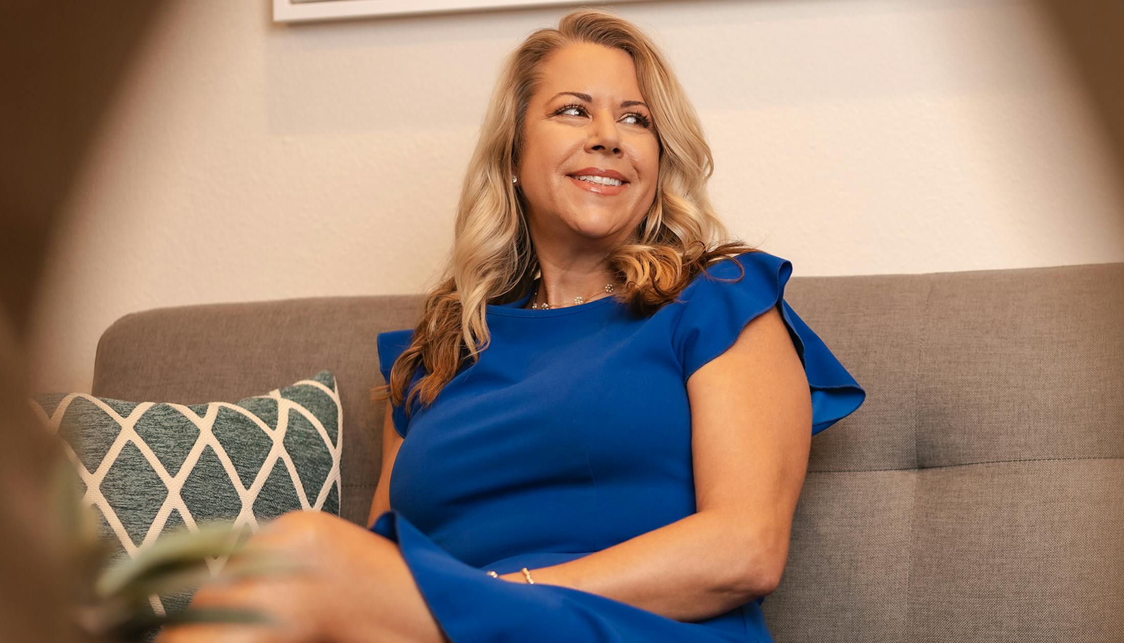 woman in blue dress sitting on couch