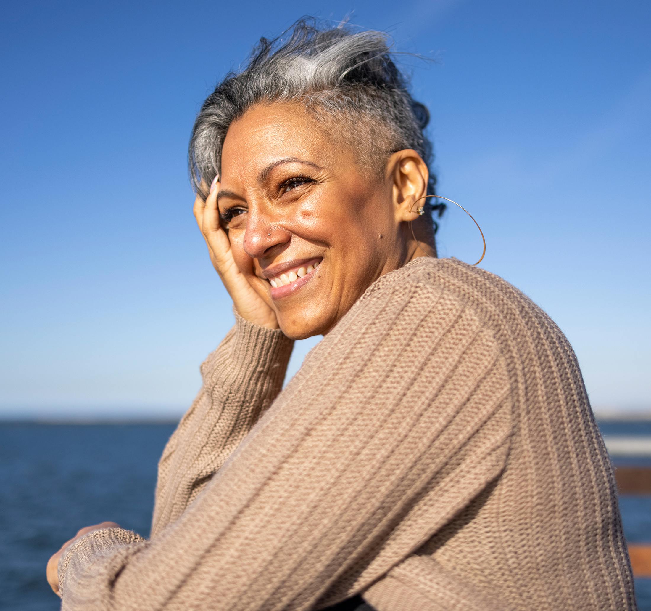 older woman smiling with her head in her hand