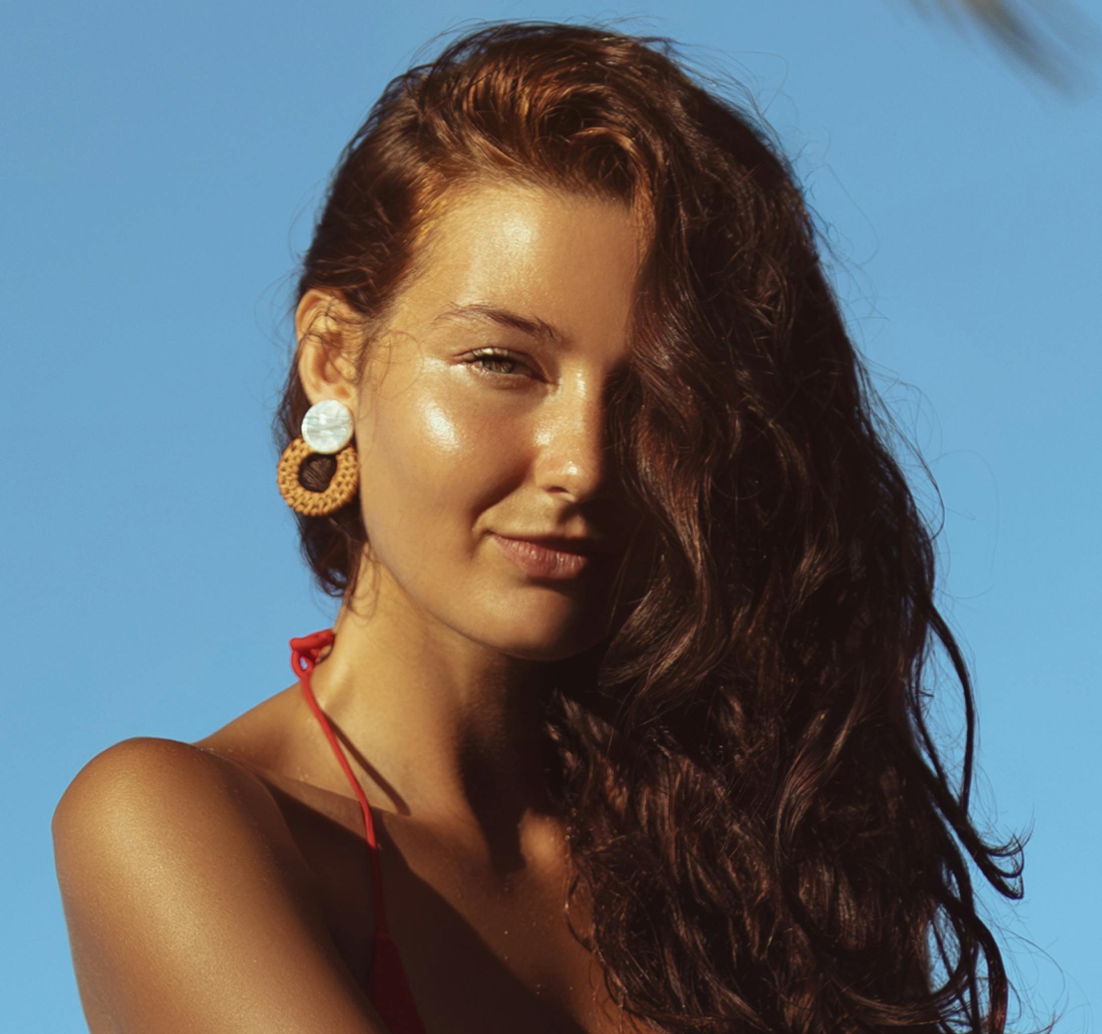 woman with hair covering her right eye and the sun hitting her left side