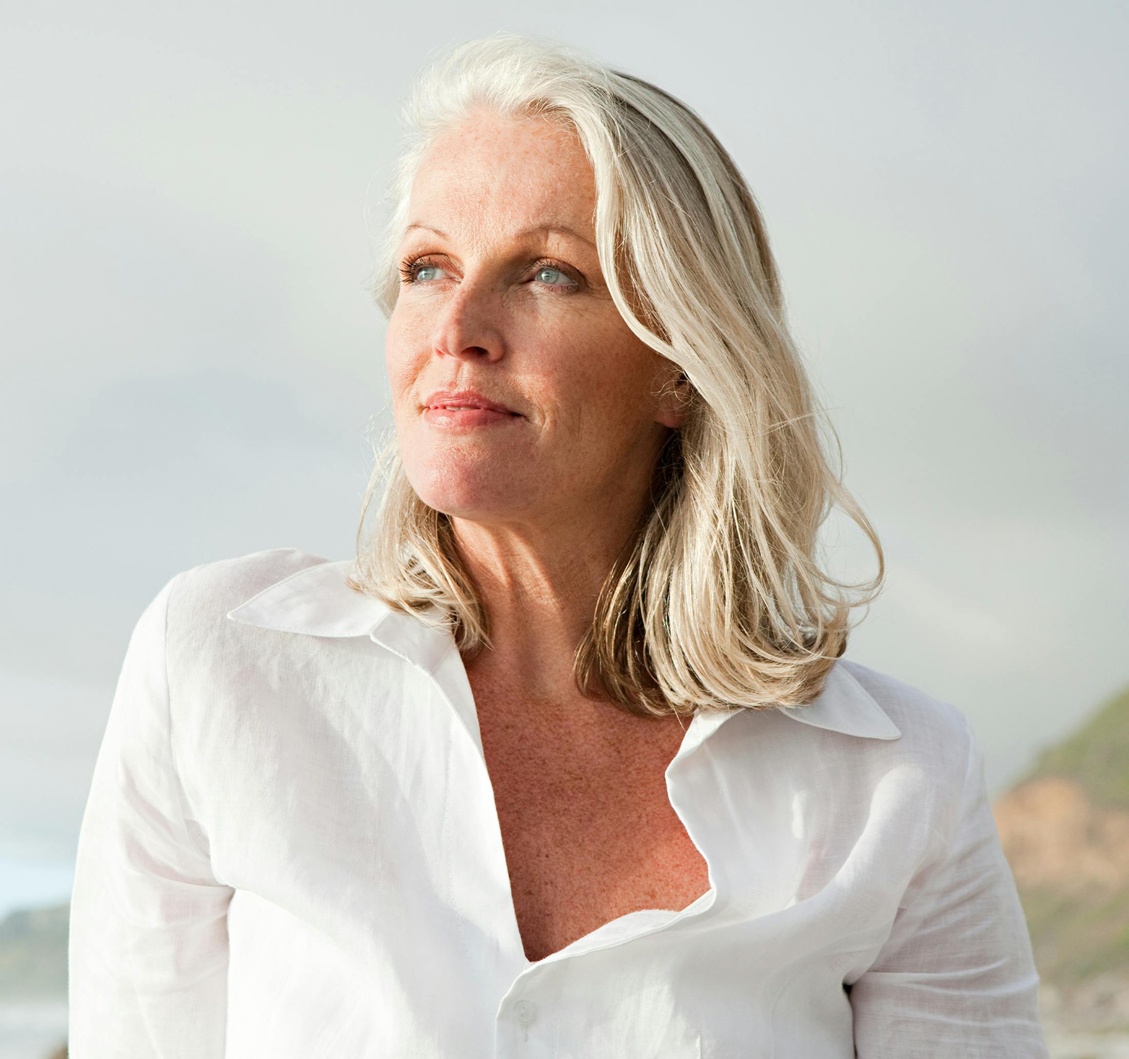 blonde woman looking outwards in white shirt