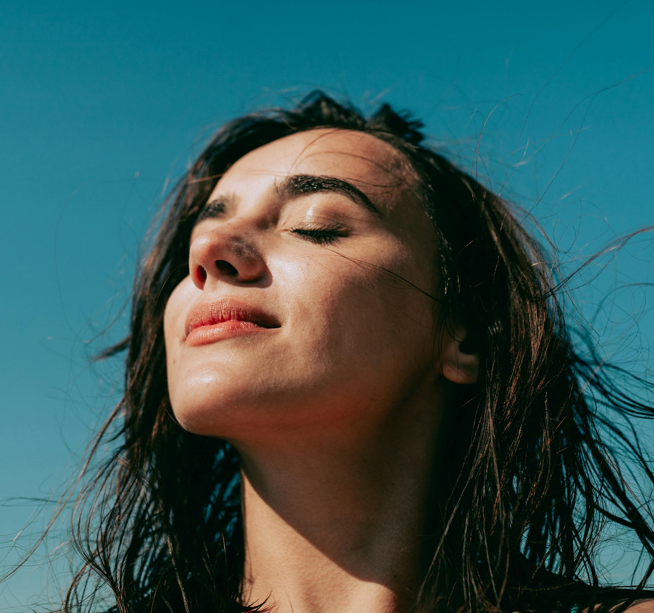 woman with her eyes closed with her head tilted to the sun