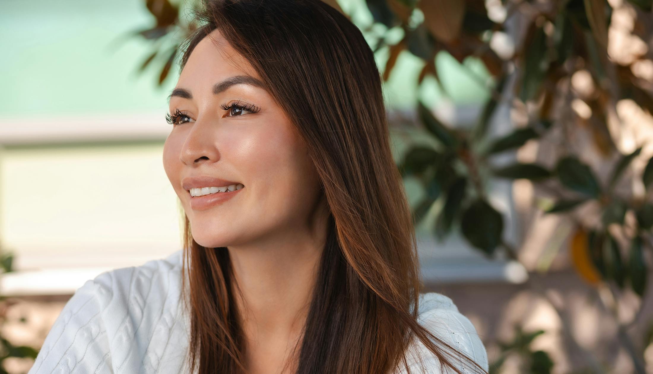 woman smiling with tree behind her