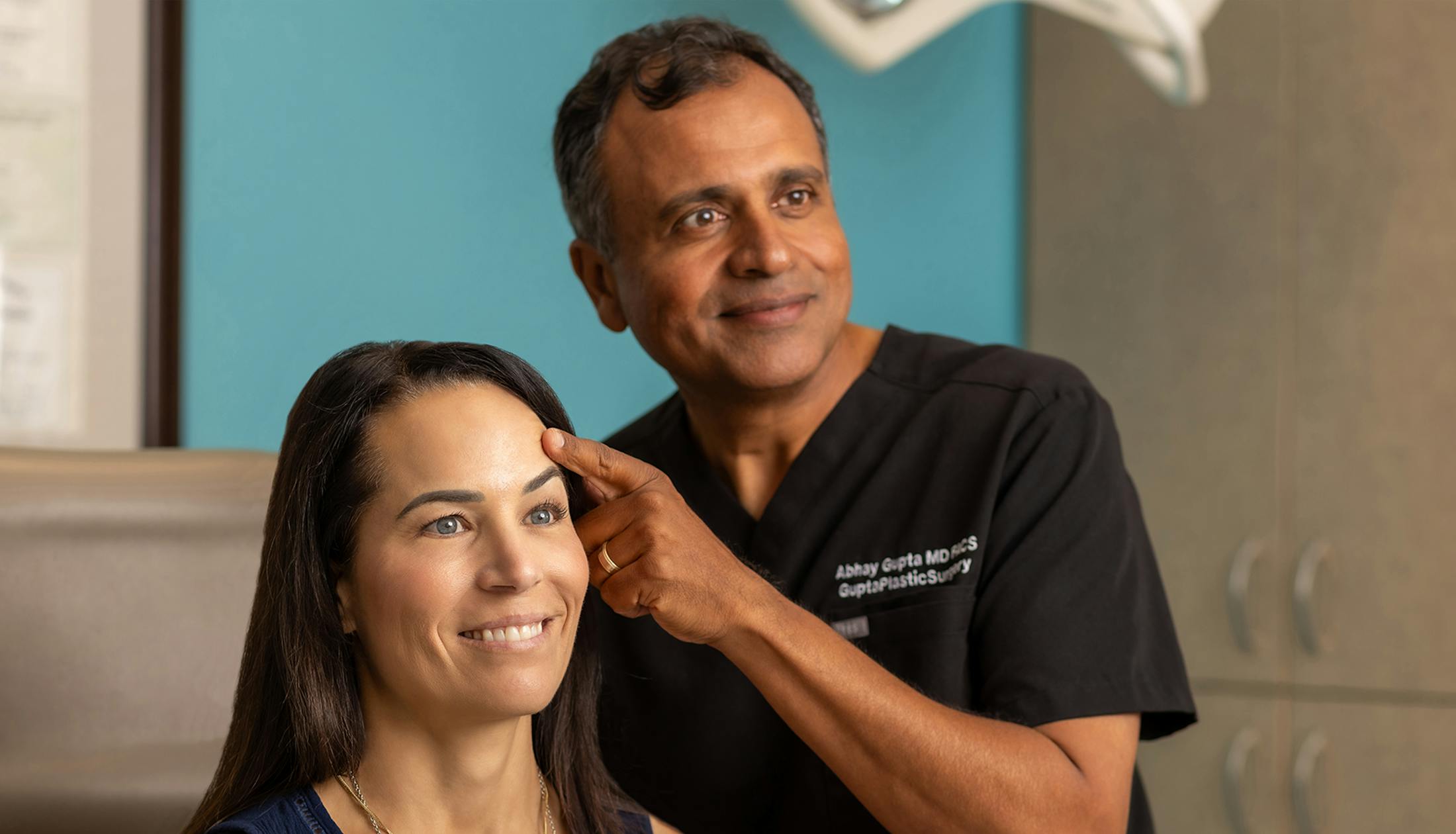 Dr. Gupta examining patient's eyebrows