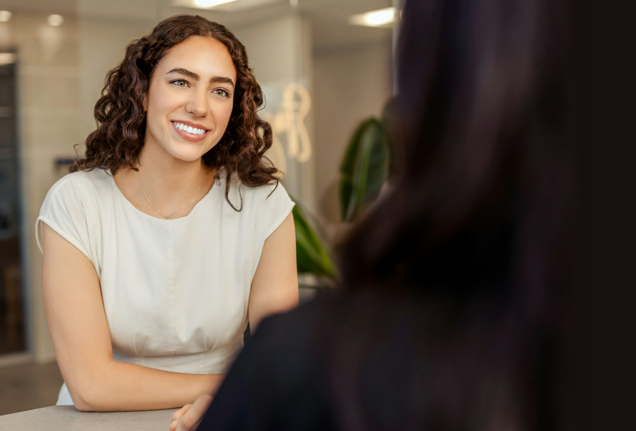 woman leaning on table smiling
