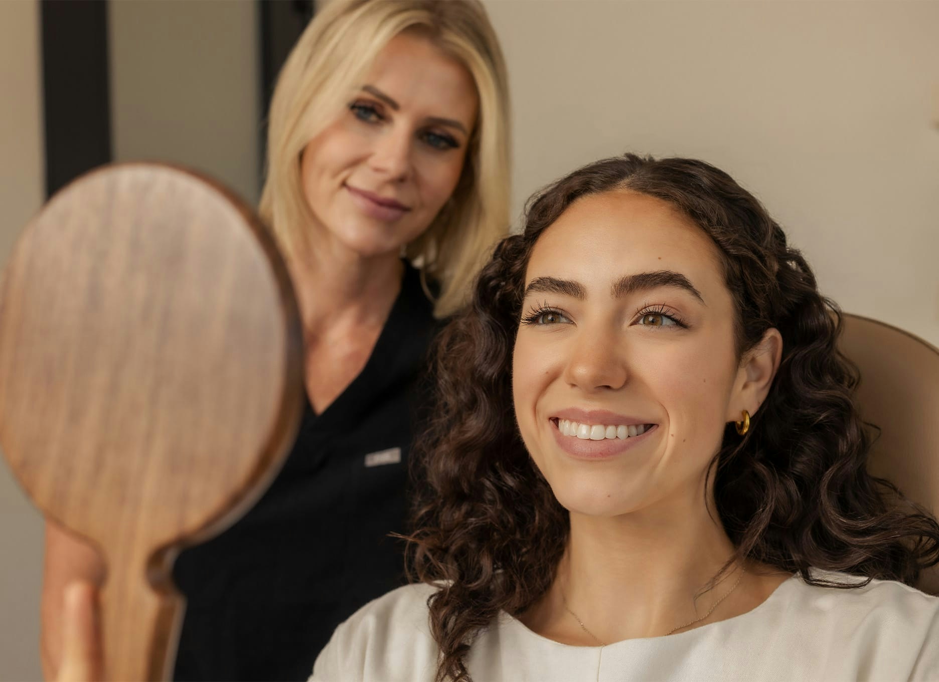 woman looking in a hand mirror