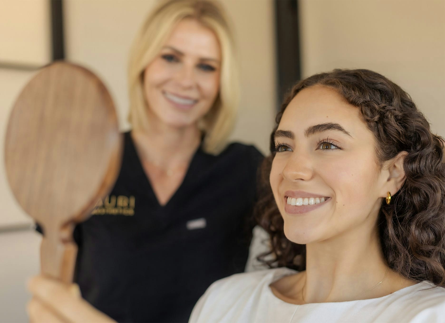 woman smiling into a mirror