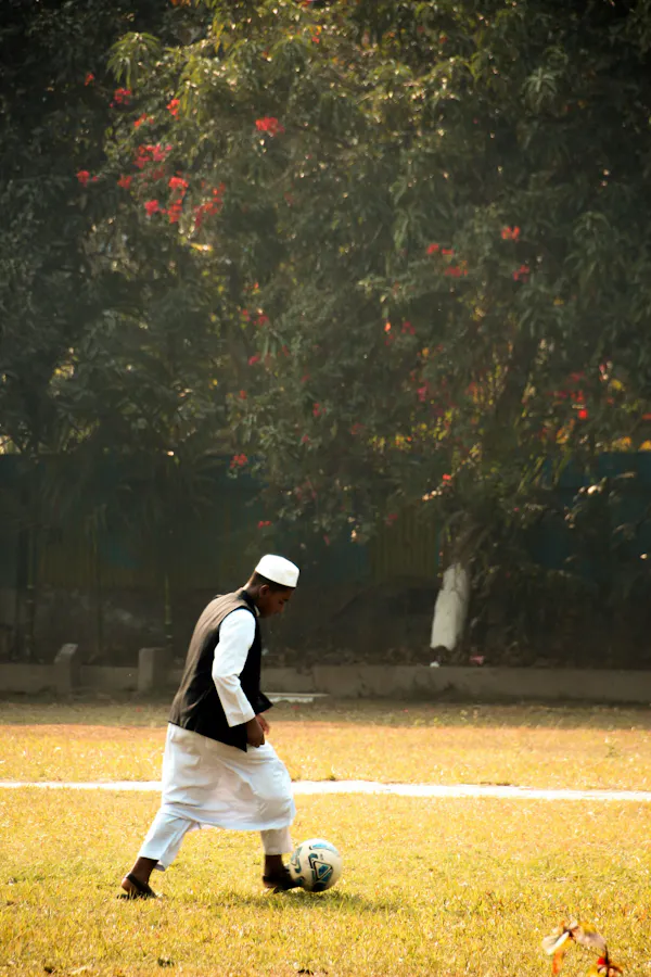 Man plays soccer on the grass field.