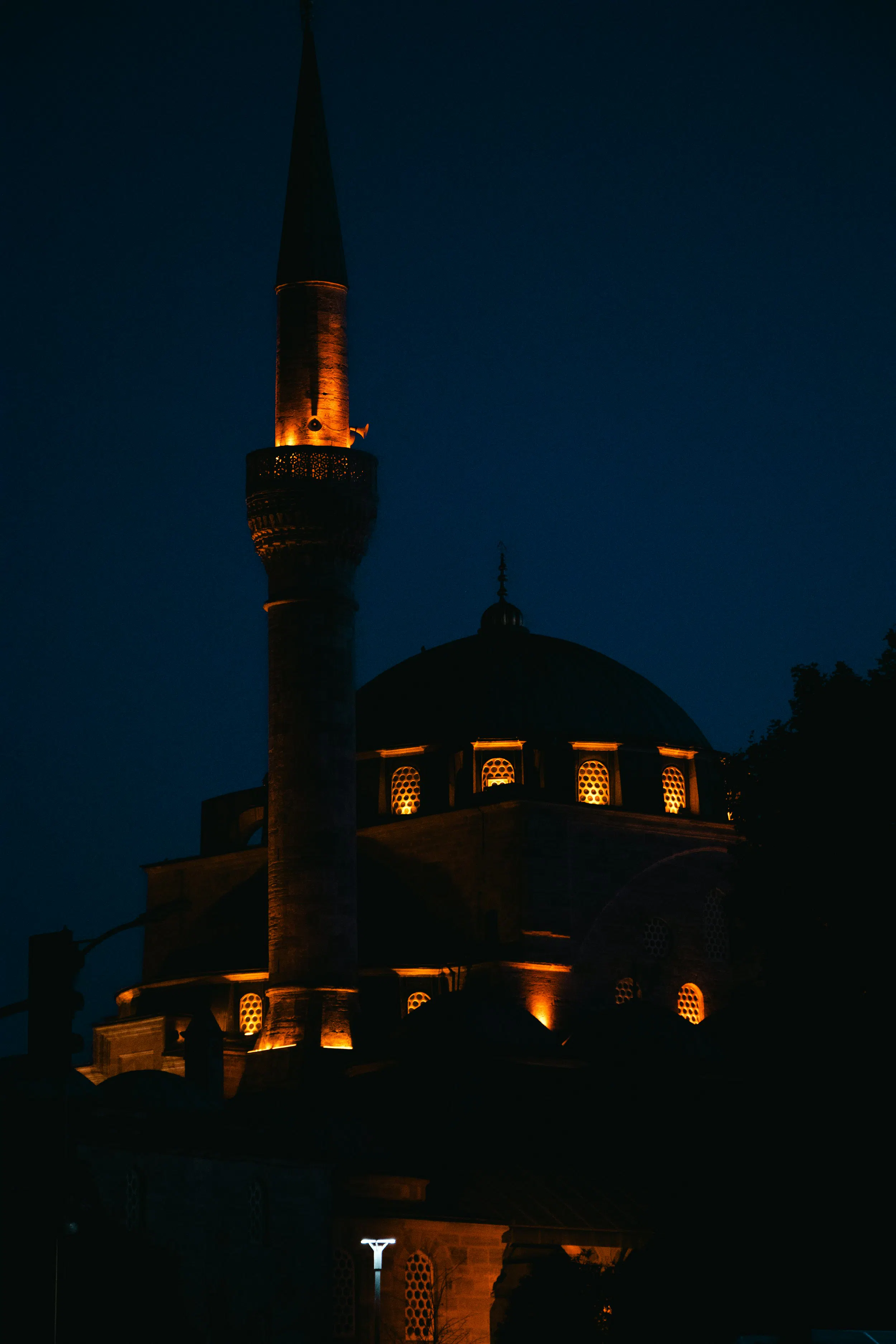 A large building with a tower lit up at night