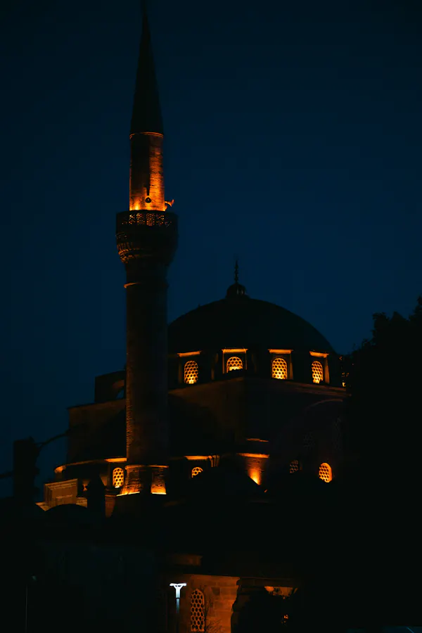 A large building with a tower lit up at night
