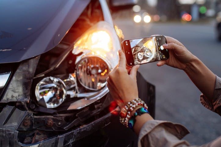 Woman taking picture of car accident