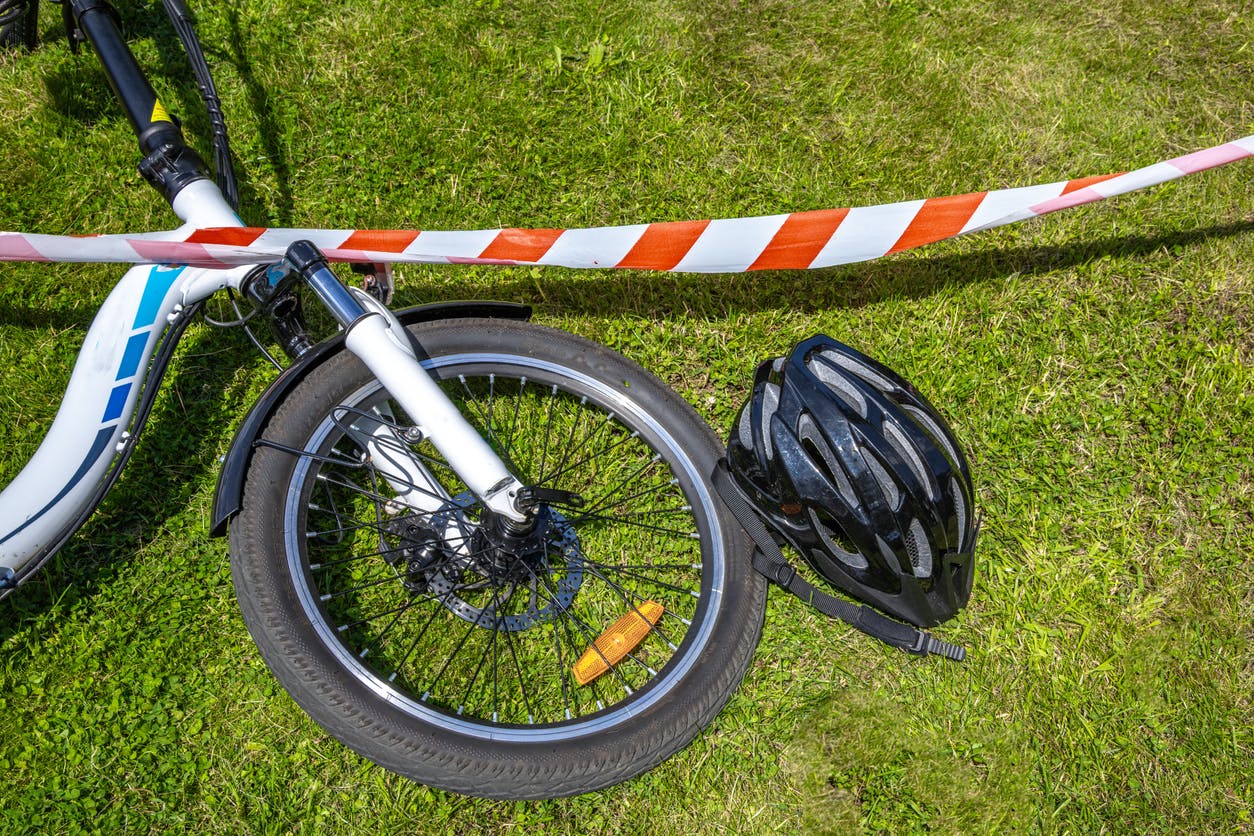 bicycle accident surrounded by red and white warning tape