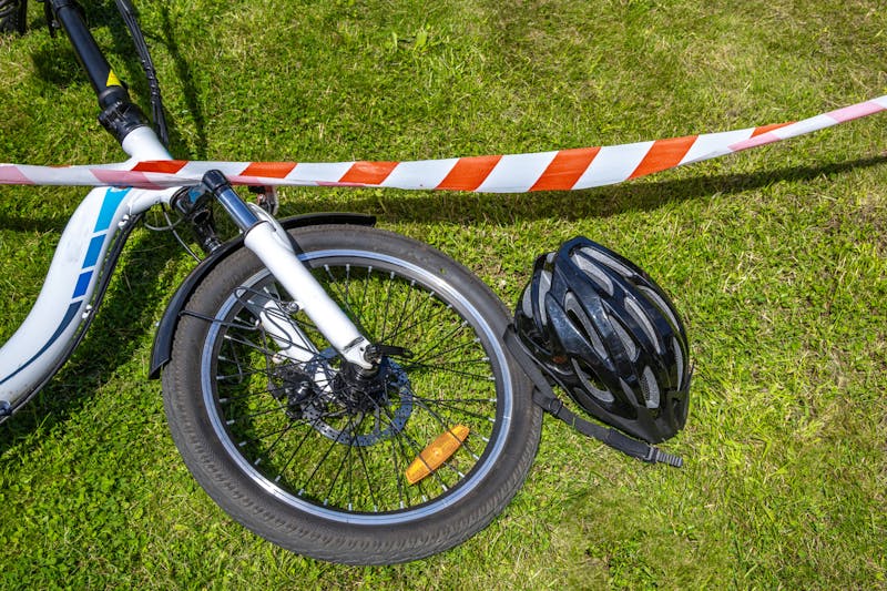bicycle accident surrounded by red and white warning tape