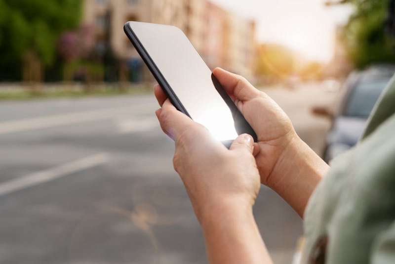 A personan on their phone ordering a rideshare