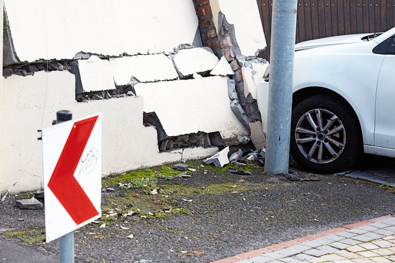 white car crash into building