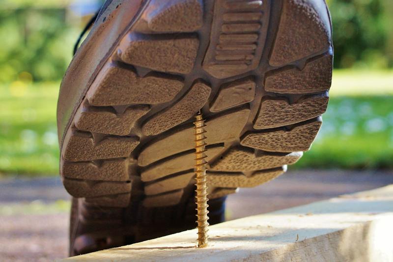 A foot stepping on a nail