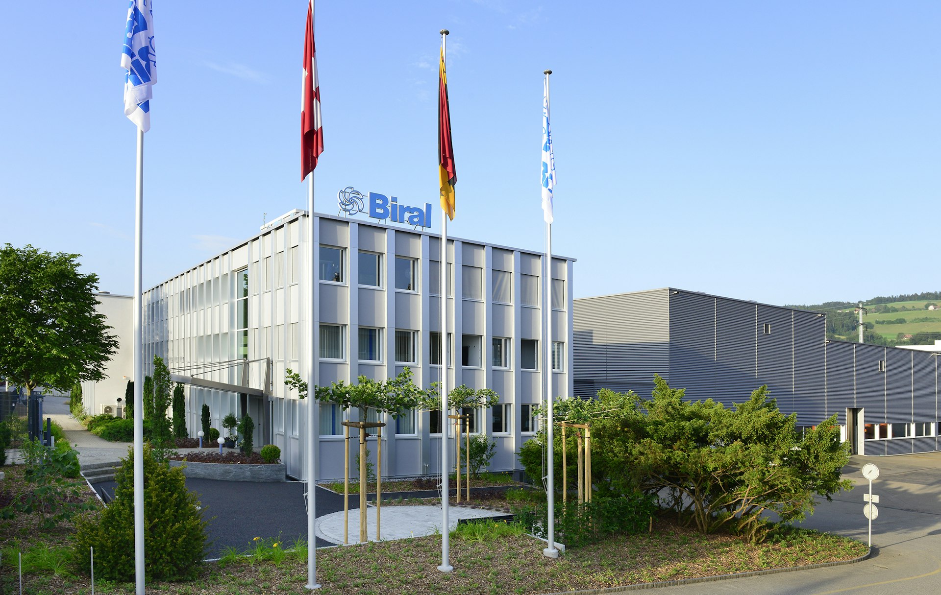 Das Biral-Firmengebäude mit Fahnenmasten davor.