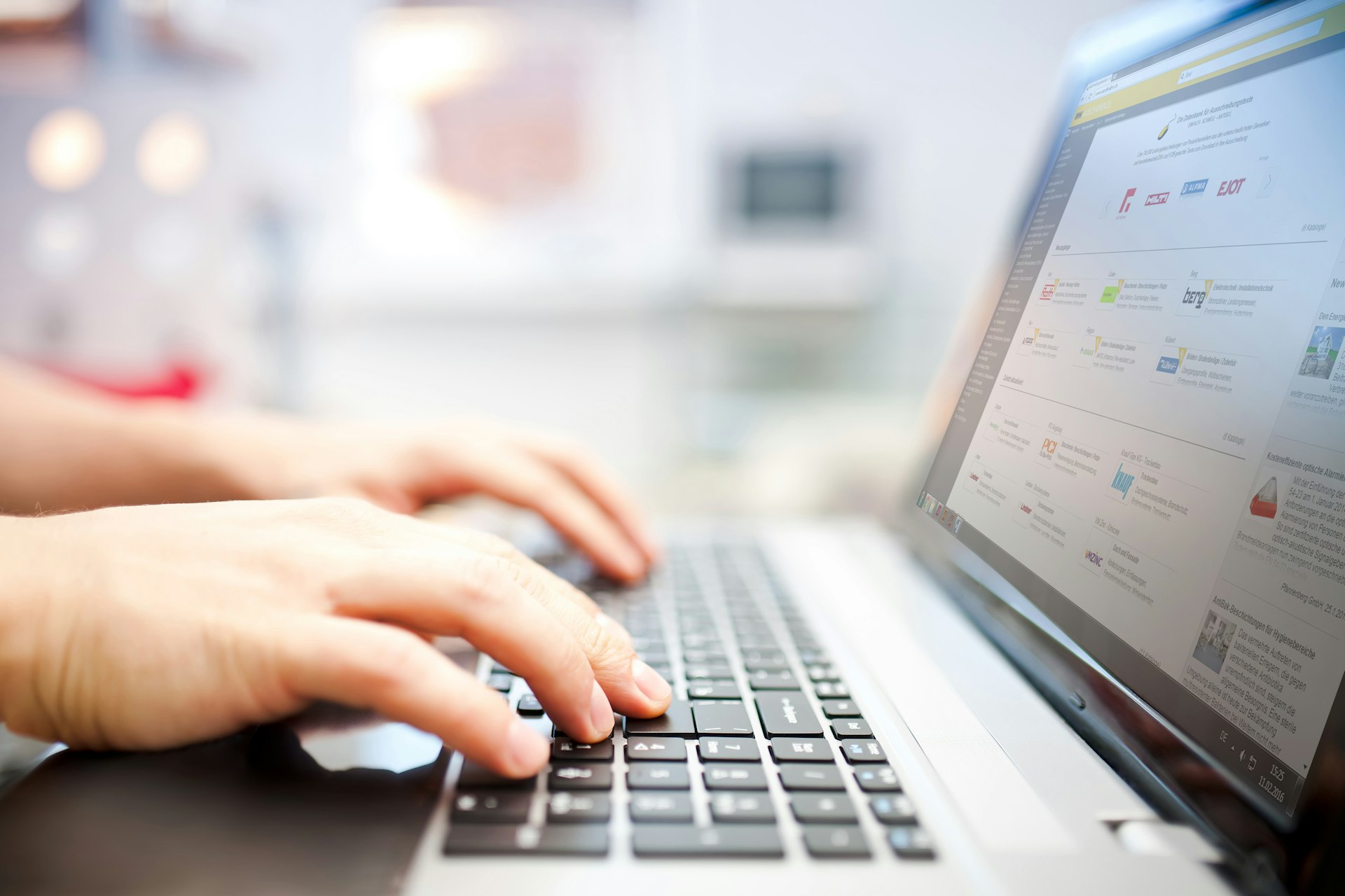 Hände tippen auf einem Laptop mit der Biral Ausschreibungshilfe