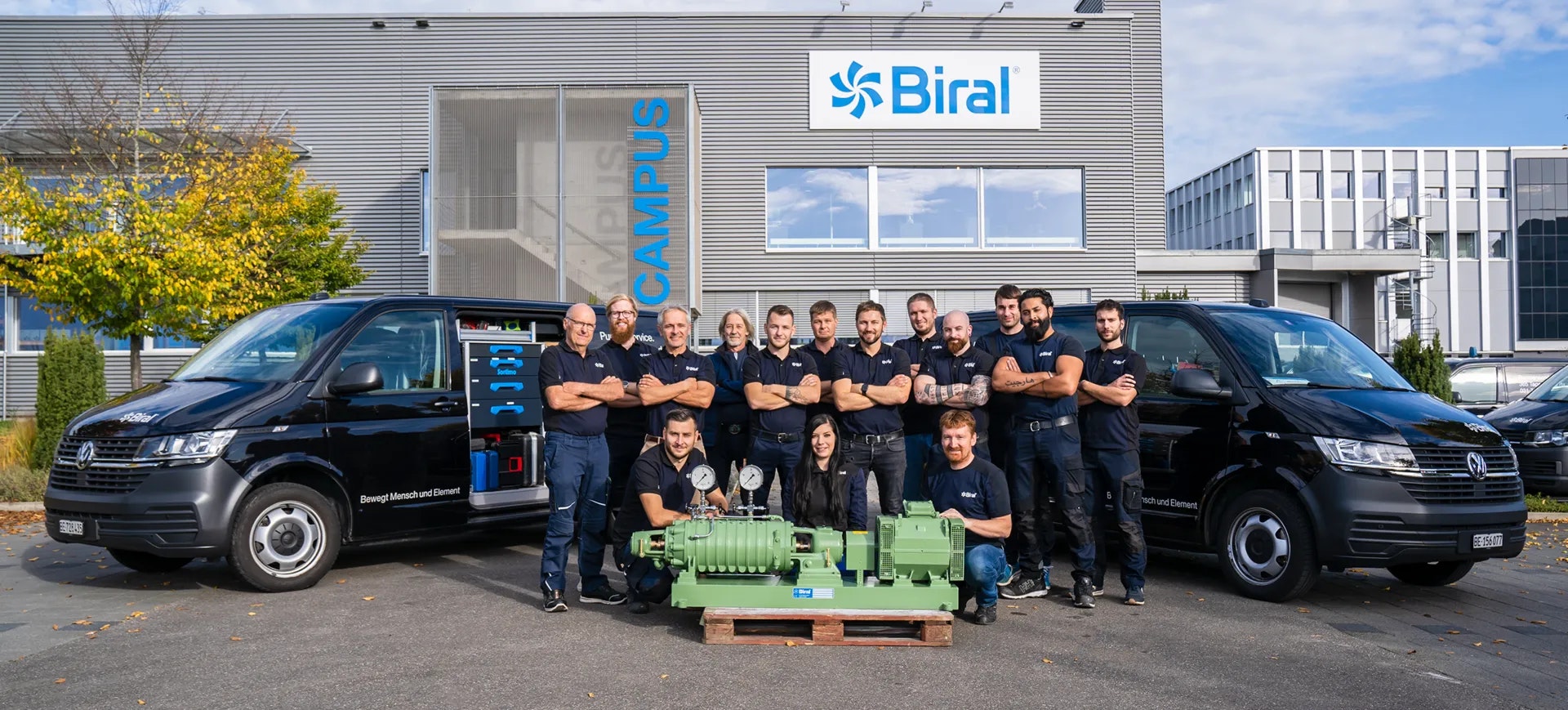 Serviceteam der Biral AG vor dem Firmengebäude mit Servicefahrzeugen