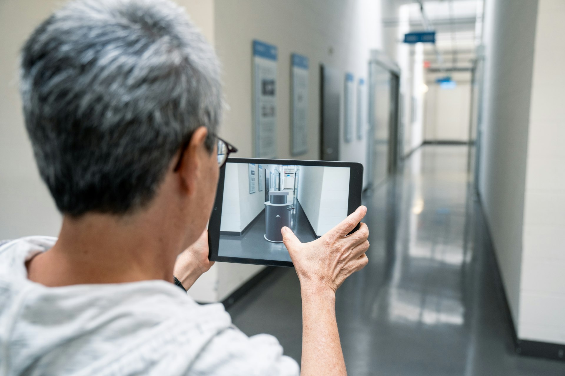 Mitarbeiterin erfasst eine Pumpe mit dem Tablet