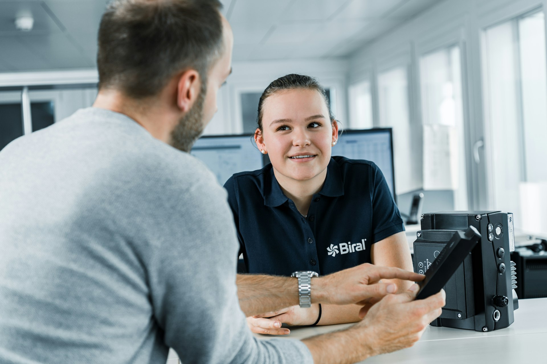 Lernende bei Biral bespricht mit ihrem Ausbildner ein Pumpen-Regelmodul.