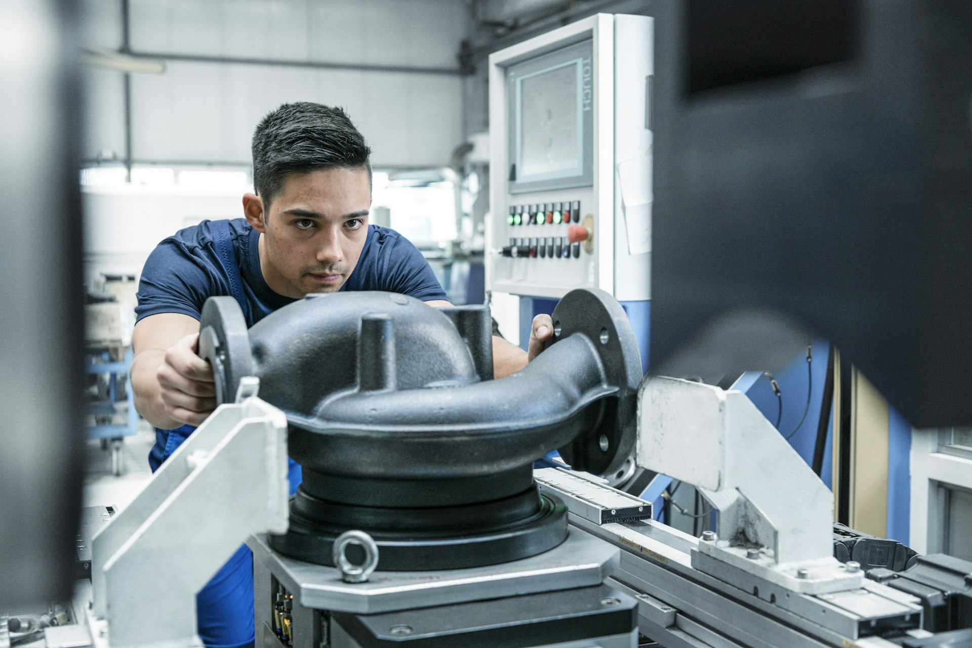 Mitarbeiter spannt ein Pumpengehäuse in eine Werkzeugmaschine.