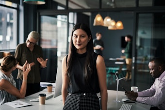Team members engage in a discussion in a bright office collaboration area.
