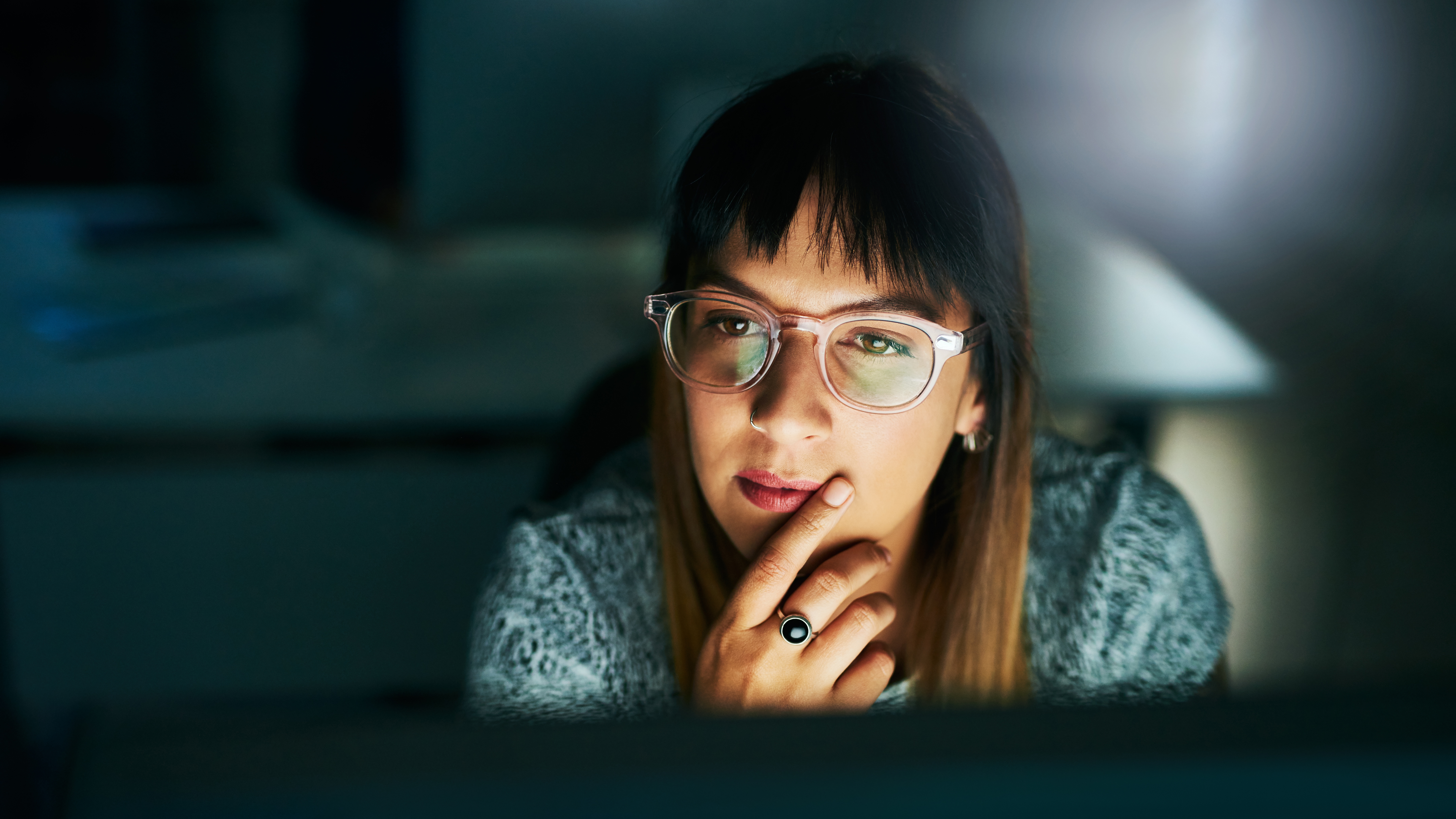 Woman looking at screen in a dark room