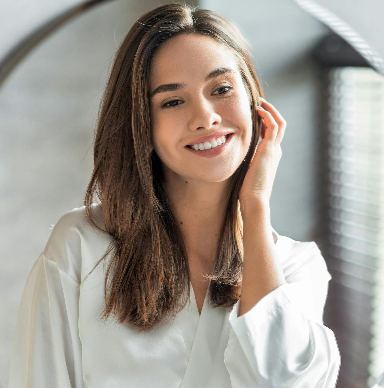 woman smiling with hand on face