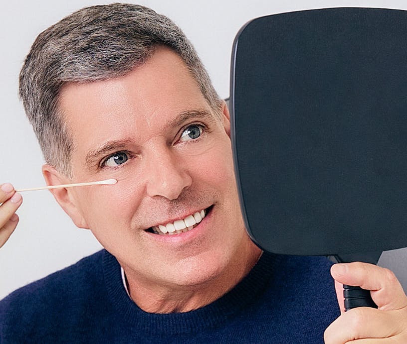 man admiring his face in mirror