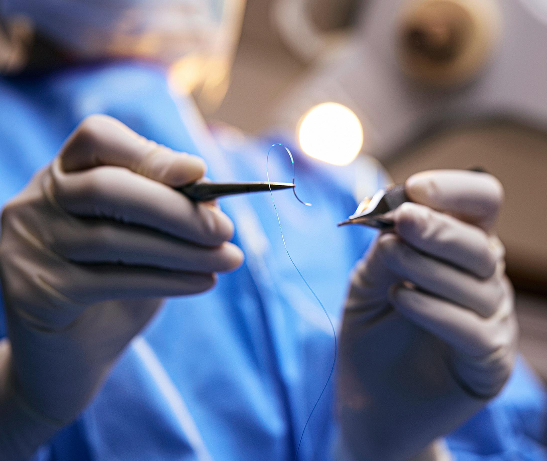 doctor threading surgical needle