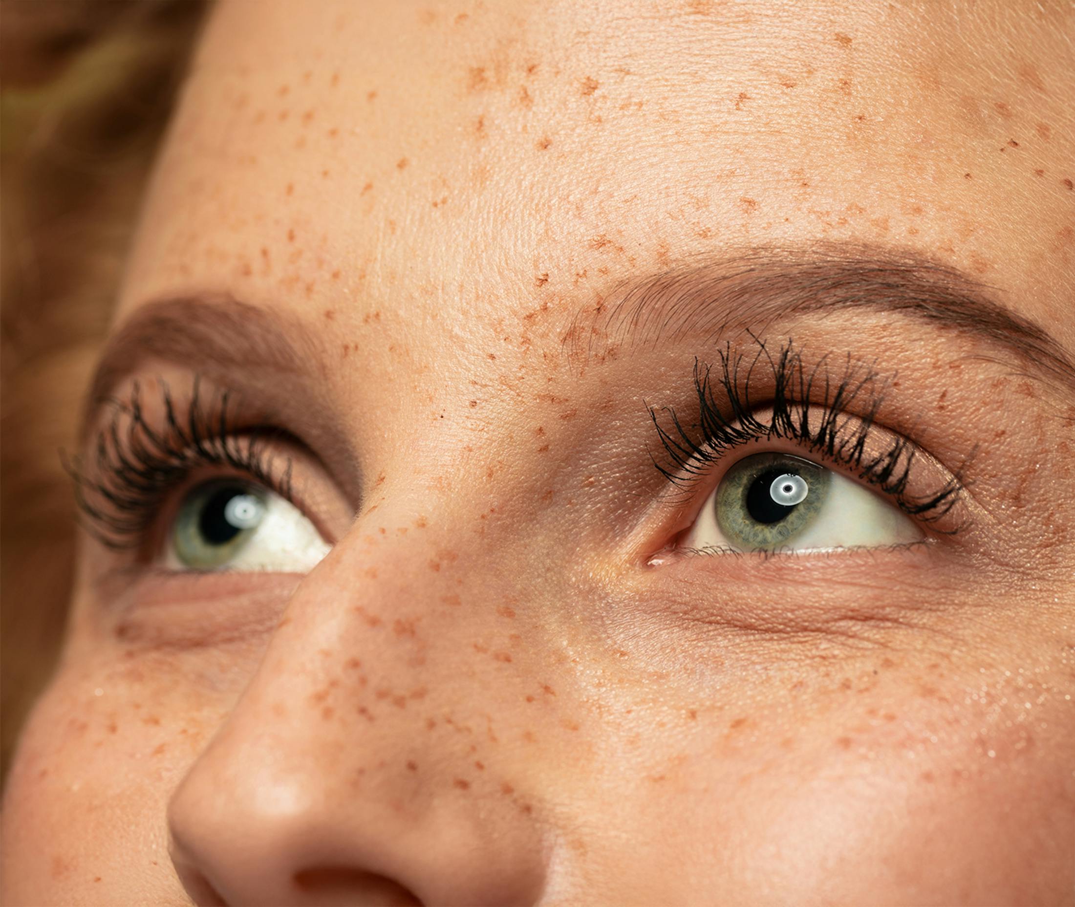 close up of womans eyes looking up