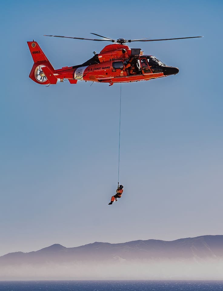 Coast Guard helicopter hoists rescue swimmer