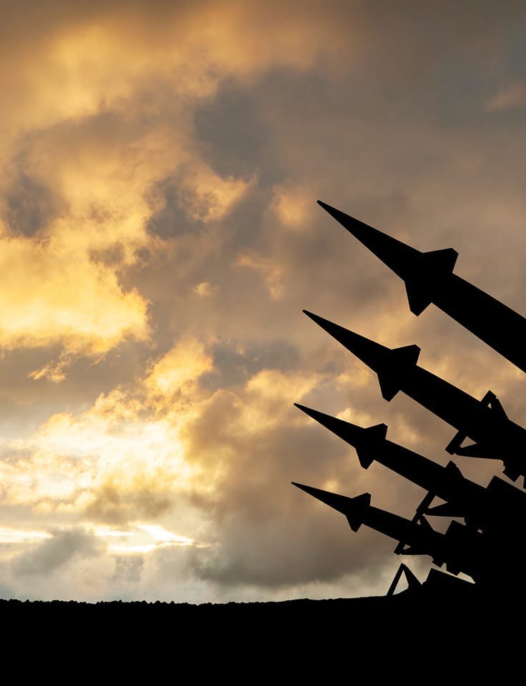 Silhouetted missiles pointed skyward at sunset