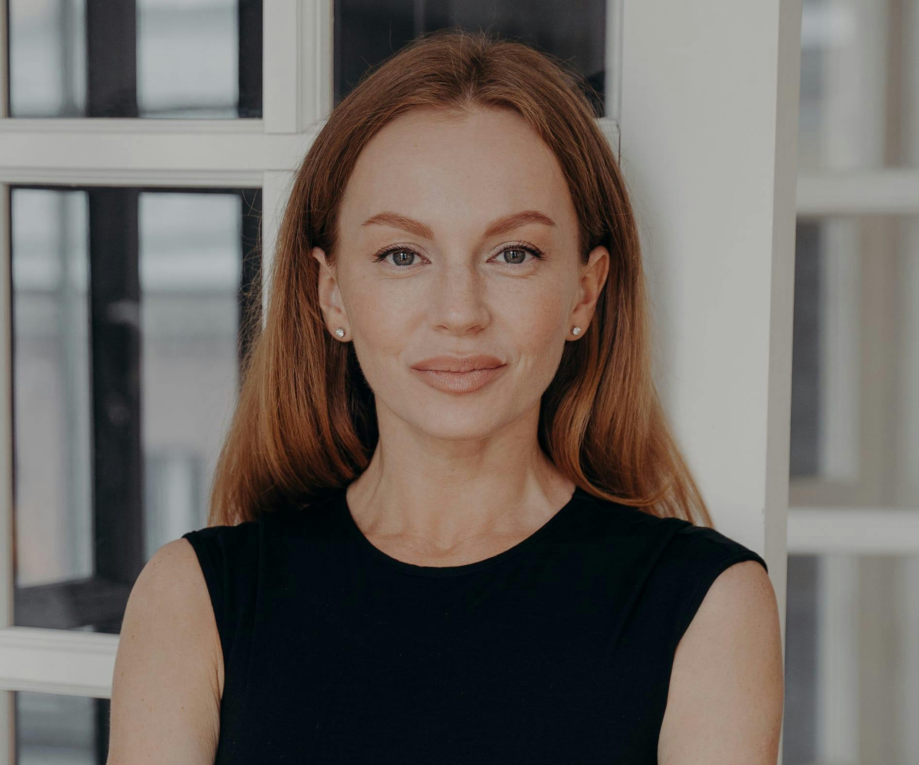 woman with orange hair looking forward