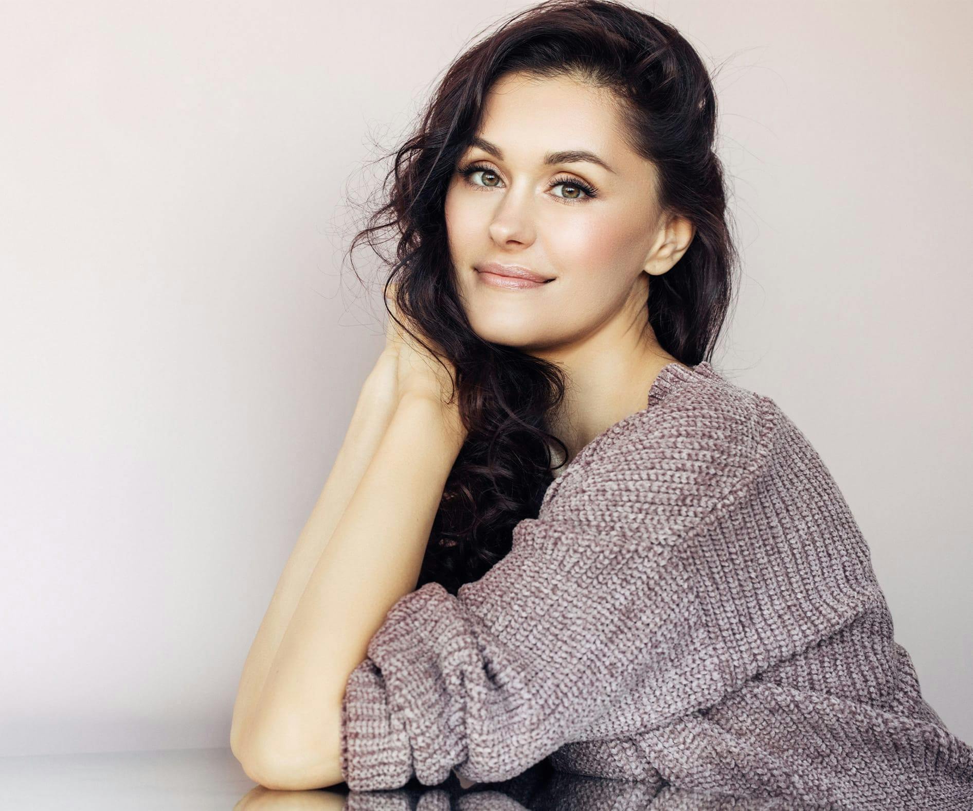 woman leaning on table with her hands nearing her face