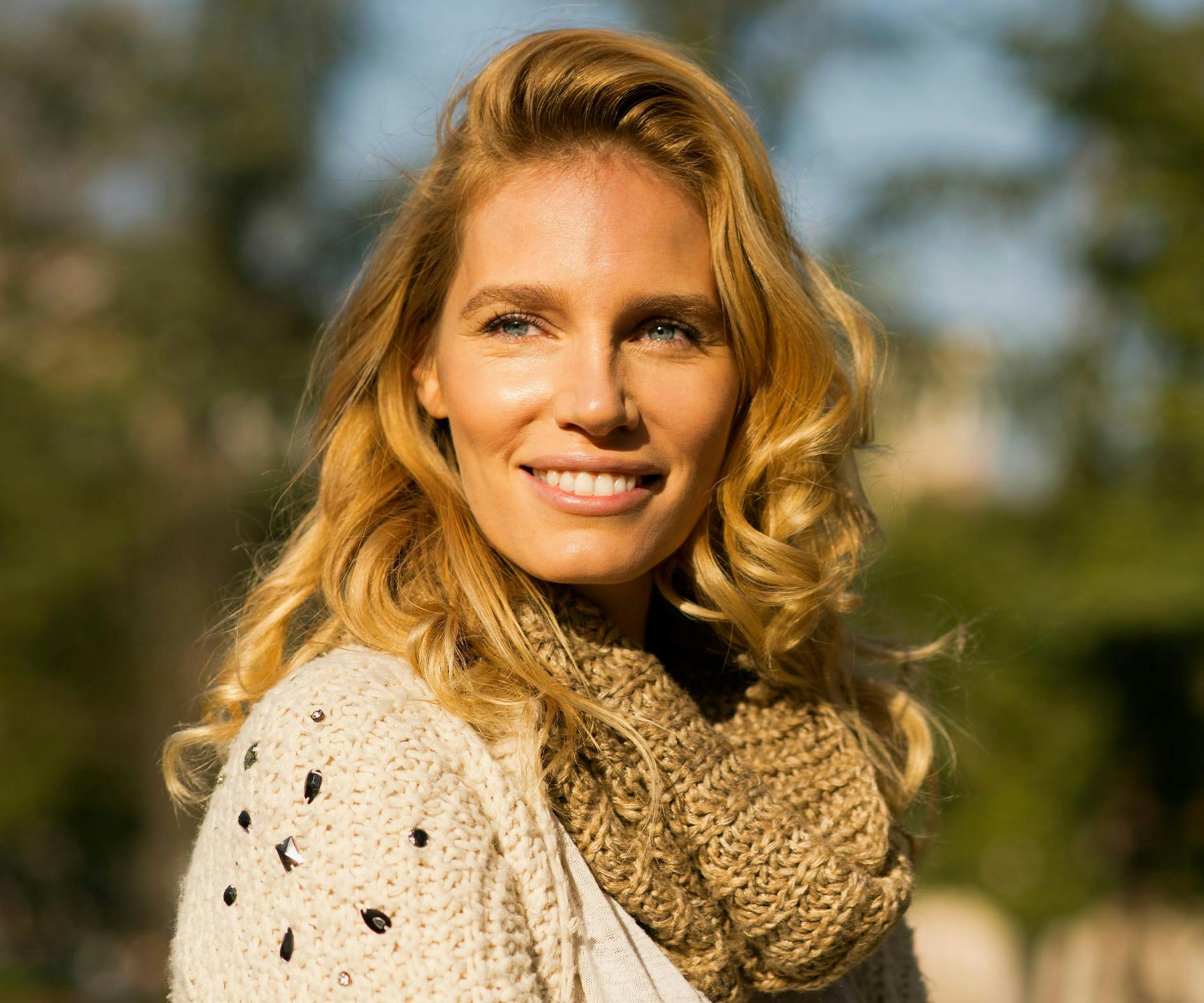 woman outside smiling with sunset lighting on her