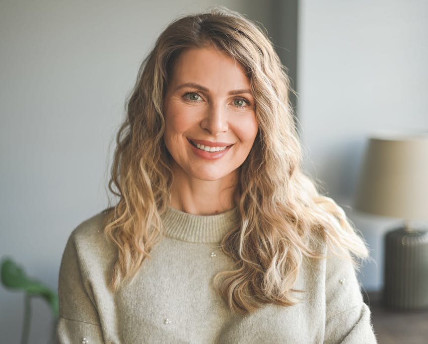woman with wavy blonde hair smiling