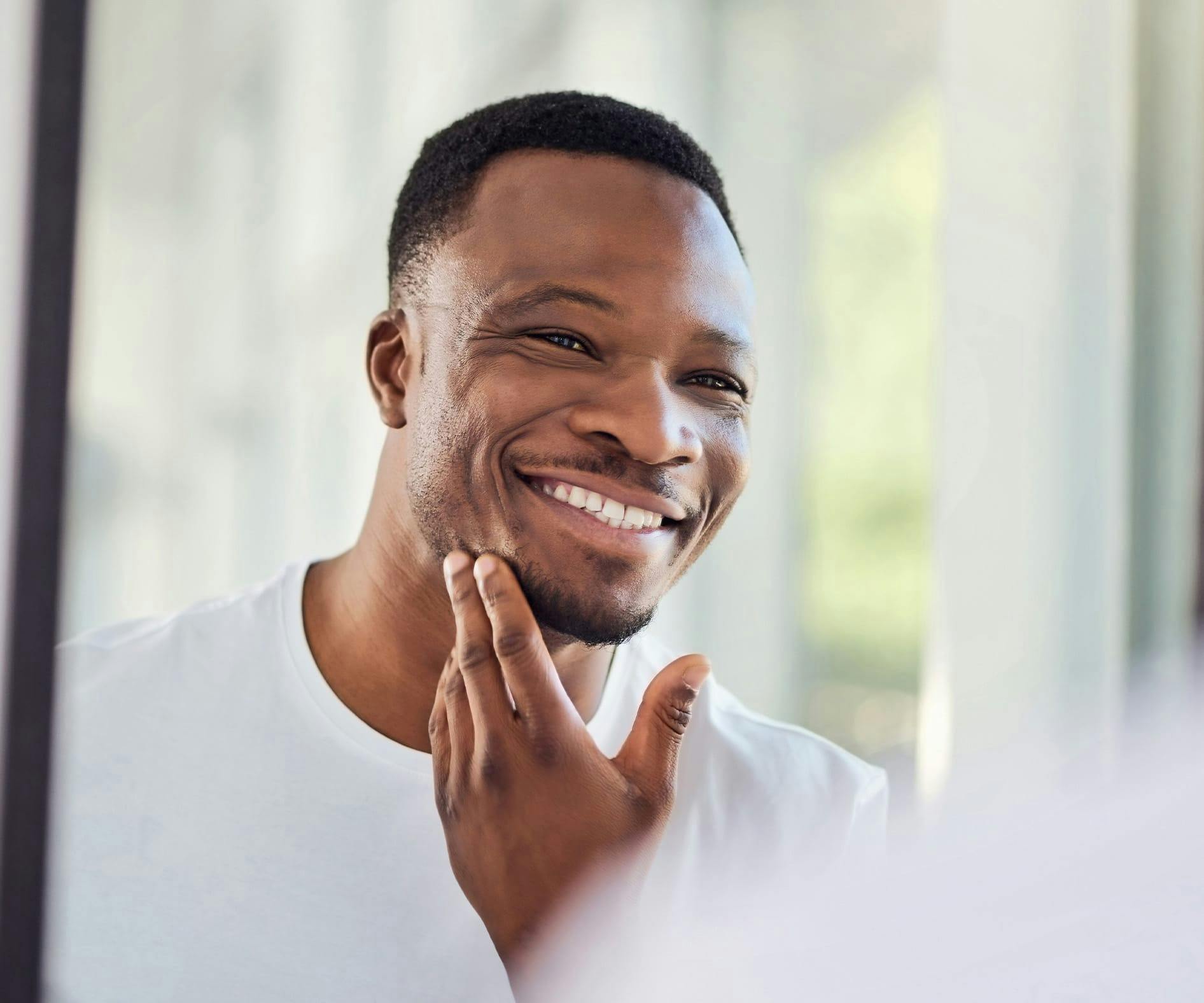 man smiling and looking in mirror