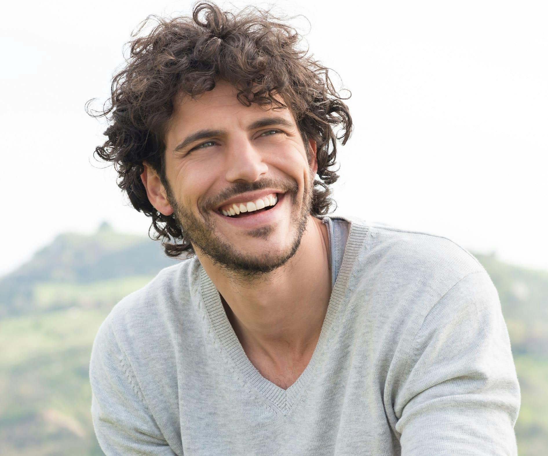 man with curly hair outside