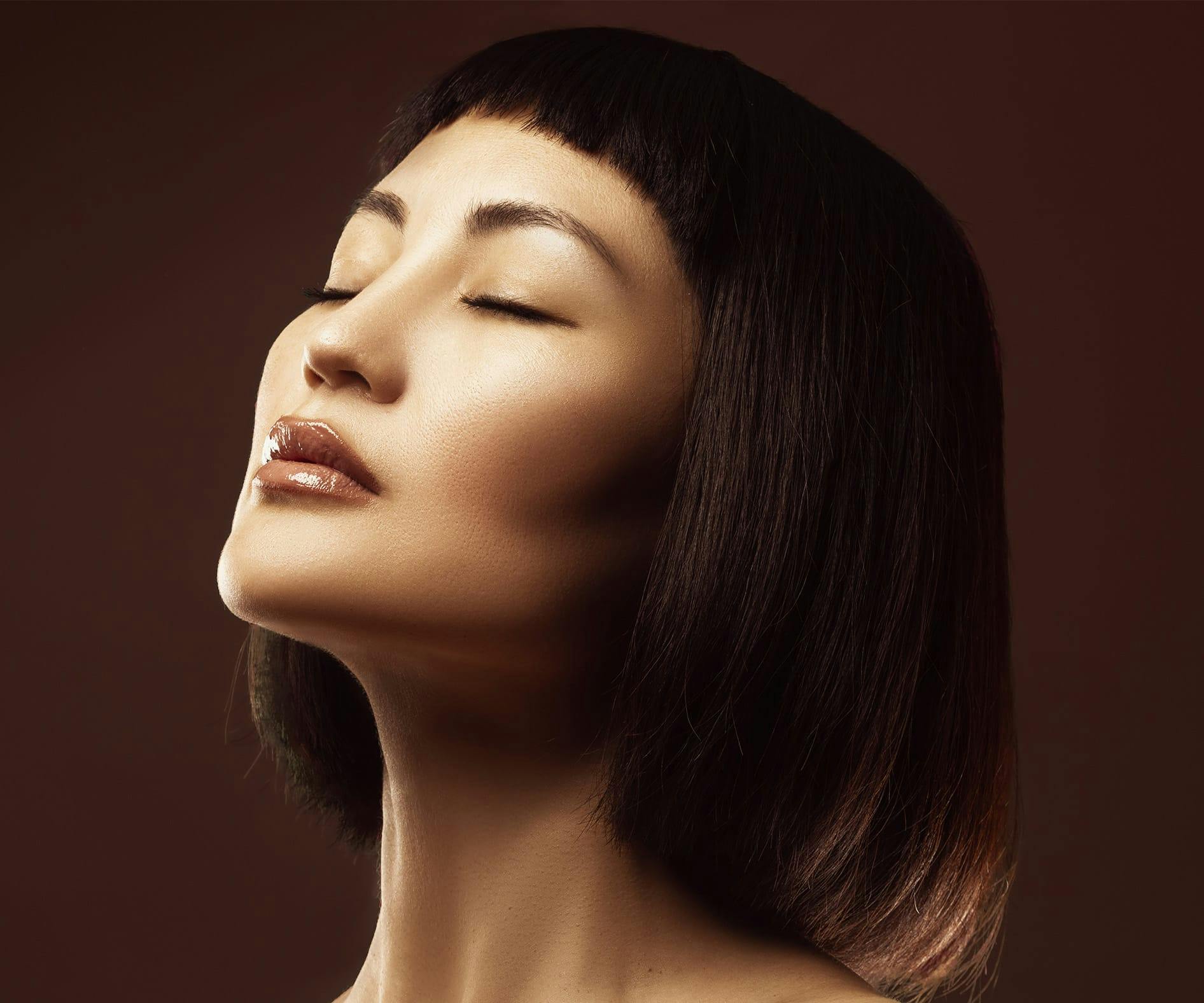 asian woman with bob haircut tilting her head upwards