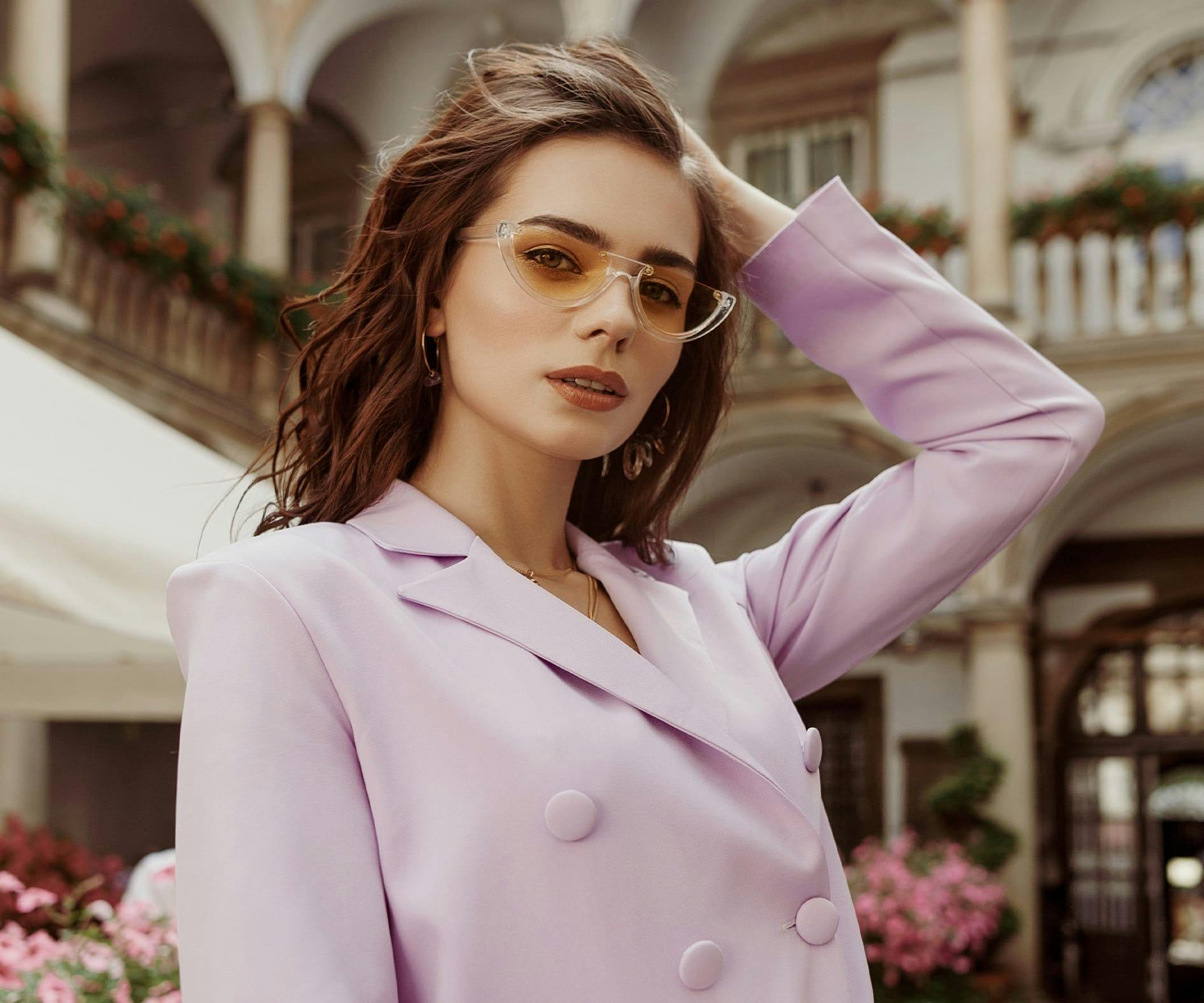 woman in pink jacket with her hand in her hair