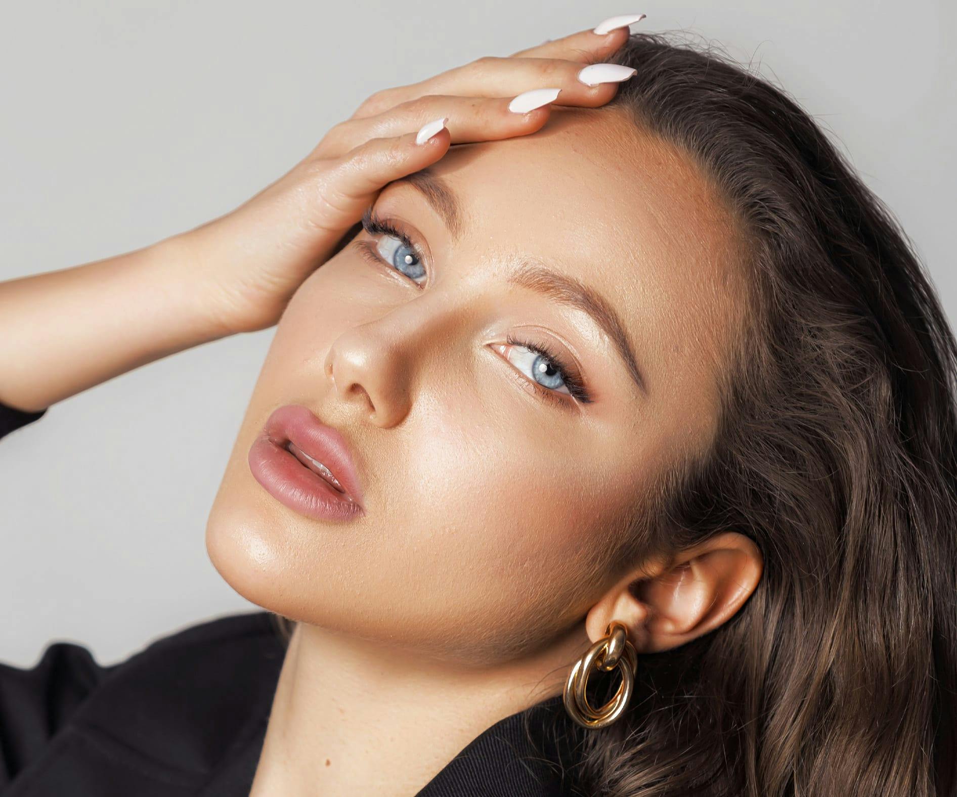 woman looking forward with her hand on her forehead